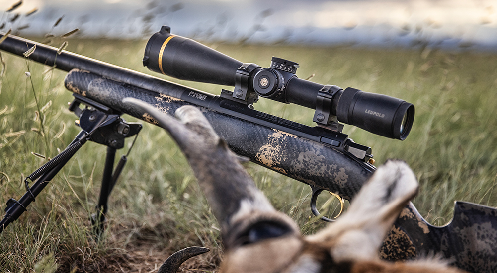 Nosler Limited Edition Model 21 Carbon rifle with bipod in grass field.