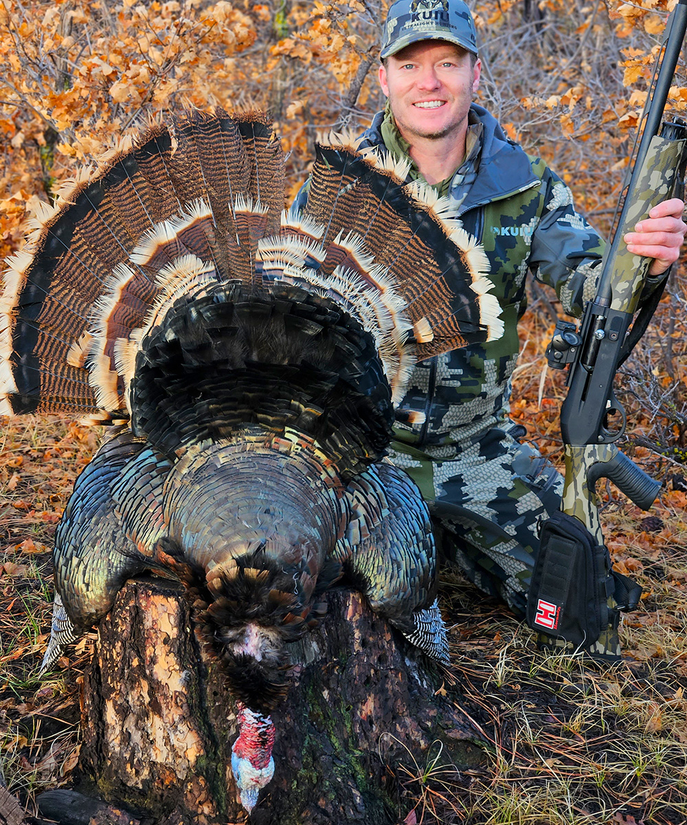 Hunter posing with wild turkey.