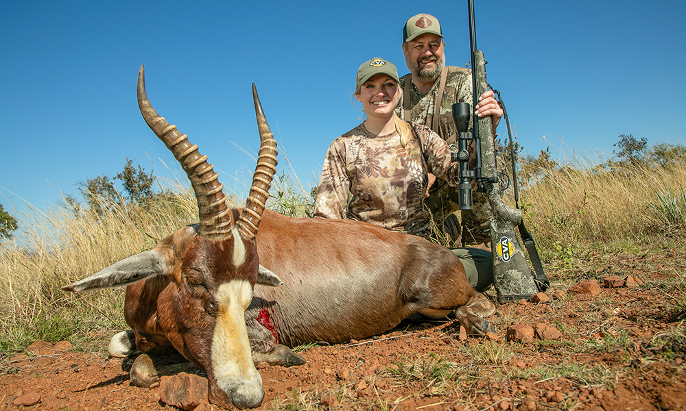 Male and female hunter posing with blesbok in Africa.