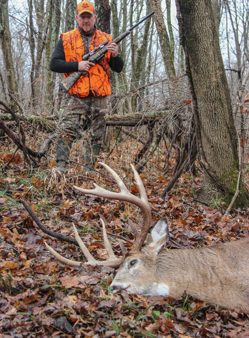 Hunter walking up on buck