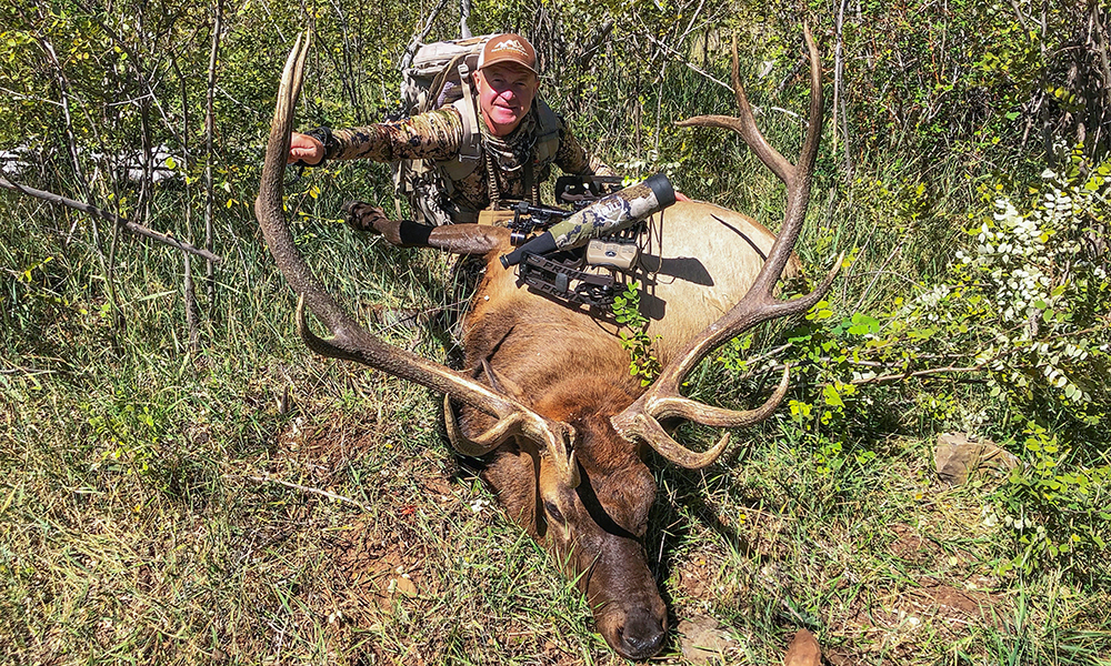 Hunter posing with bull elk.