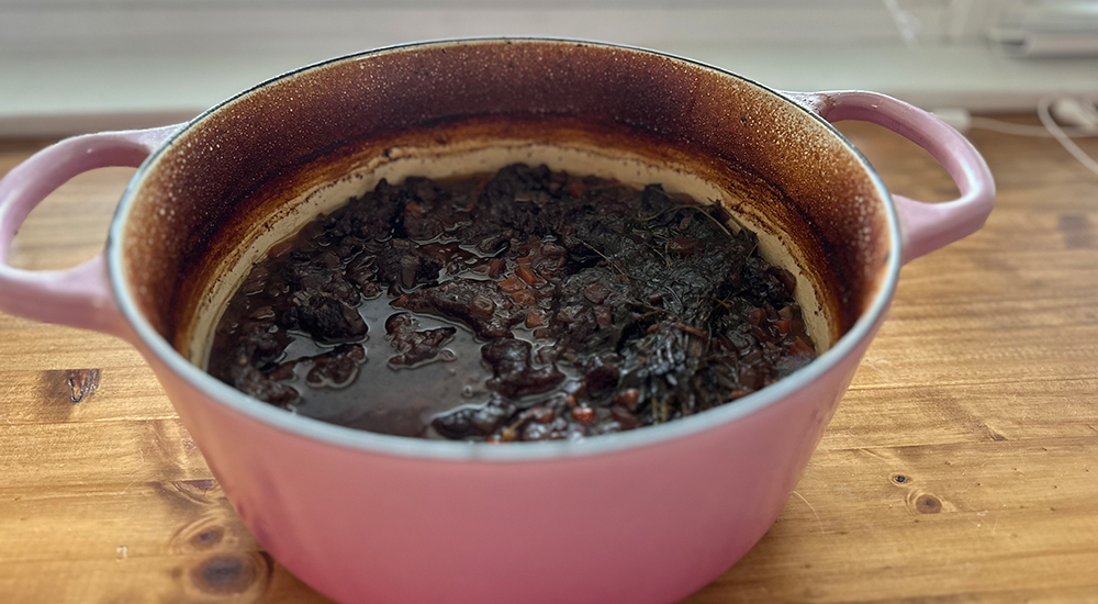 Venison Bourguignon cooking in cast iron pot.