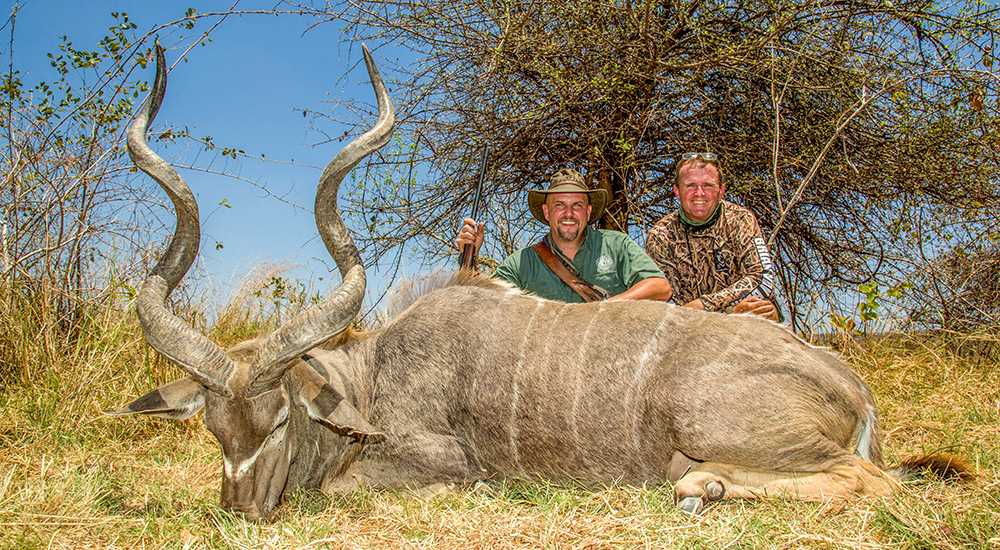 Male hunter and professional hunter posing with kudu bull.