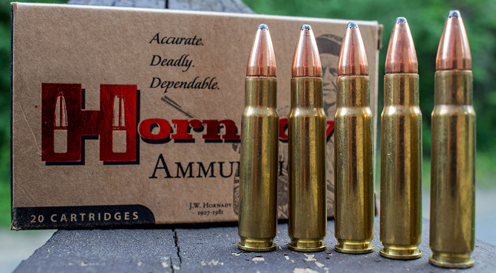 Five rounds of Hornady .358 Winchester ammunition on wooden table.