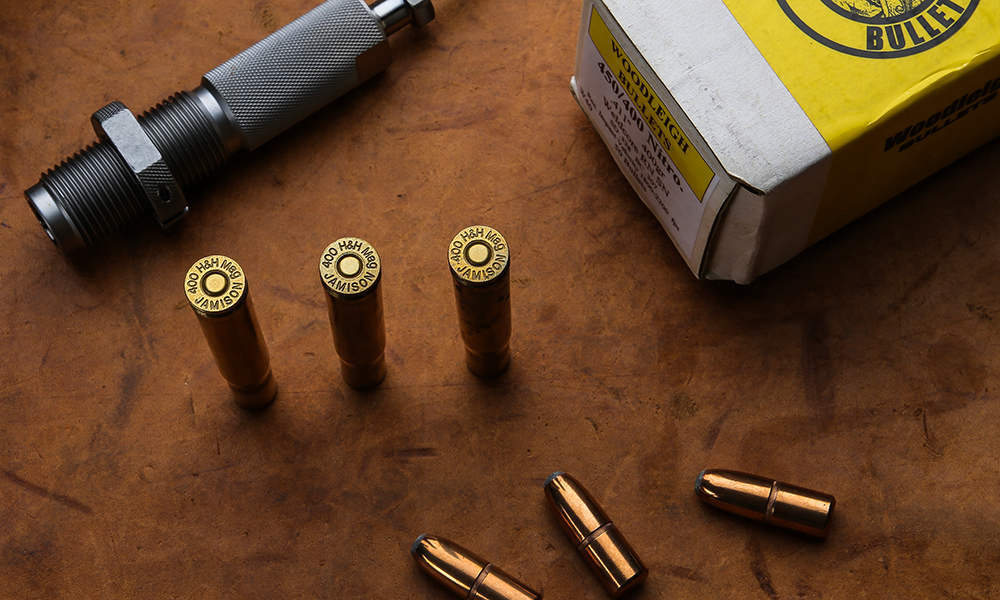 Three rounds of .400 H&H Magnum ammunition on wooden table.