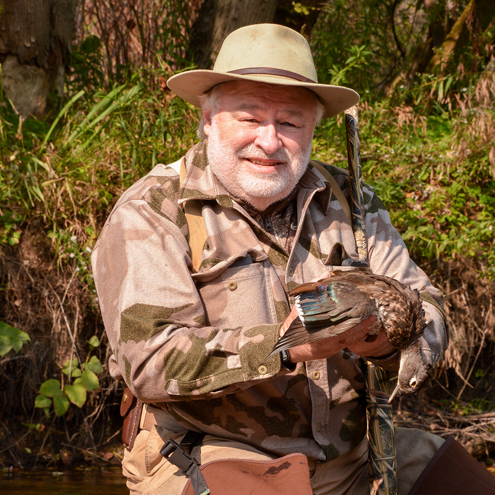 Male hunter holding wood duck.