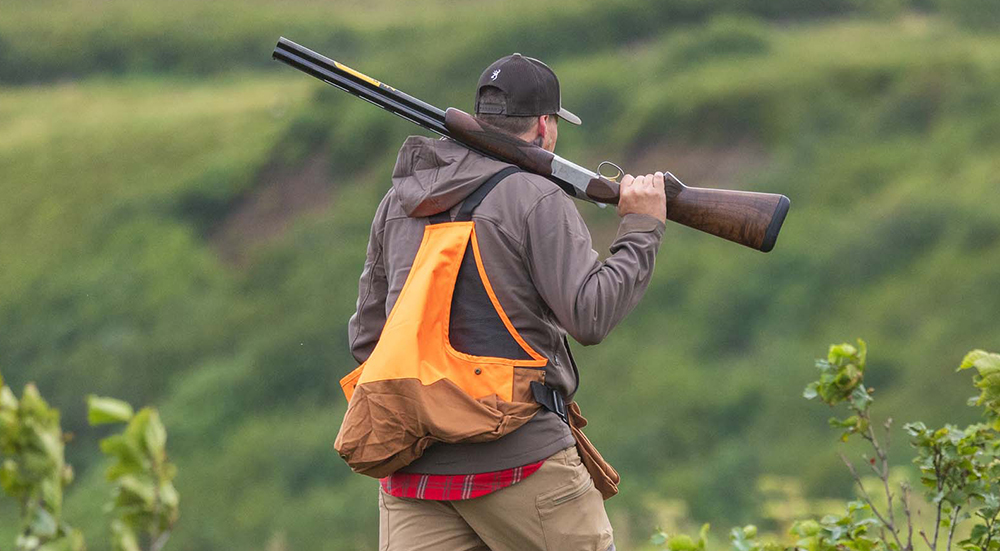 Browning Citori 825 Field on upland hunter's shoulder in field.