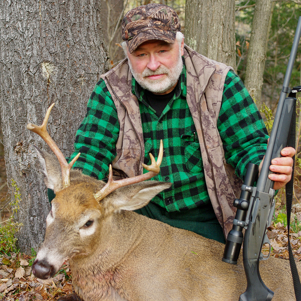 Male hunter posing with white-tailed buck taken on public land in Vermont.