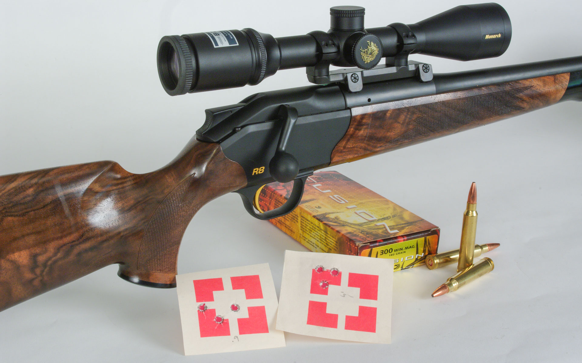 Blaser R8 with targets and ammo on white