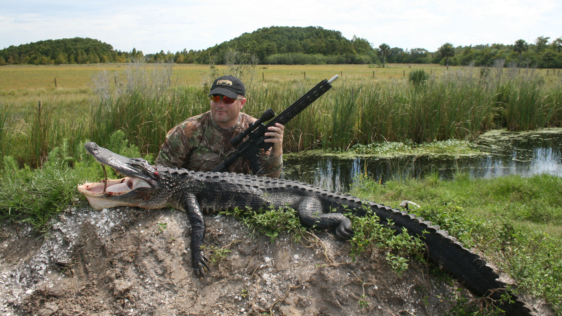 Hunter posing with gator in swamp