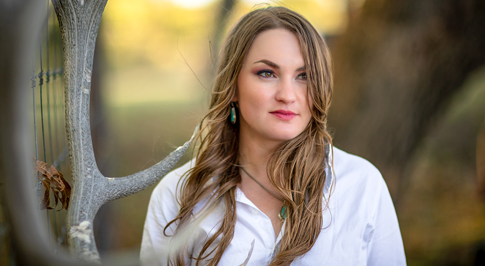 Brunette female headshot outdoors.