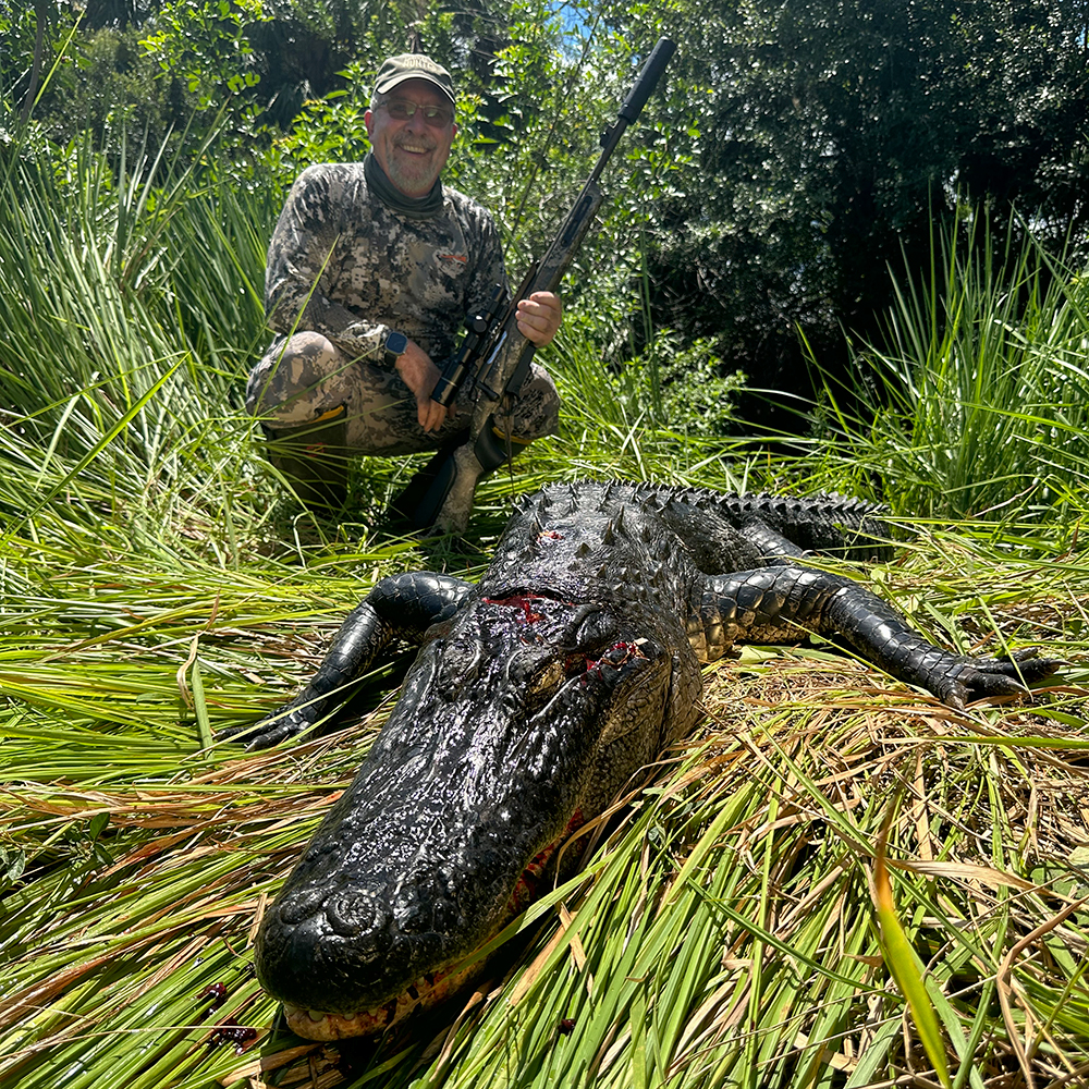 Male hunter posing with alligator killed in Florida.