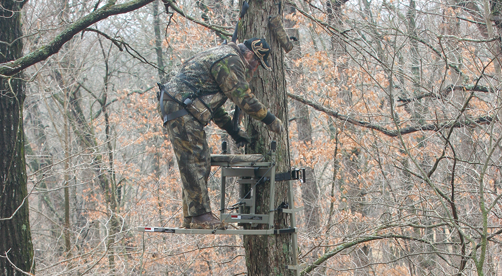 Male hunter hanging tree stand.