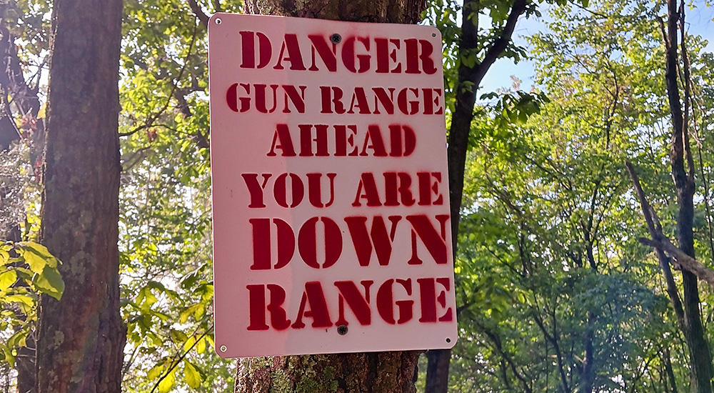 Rifle Range sign reading "Danger, Gun Range Ahead."