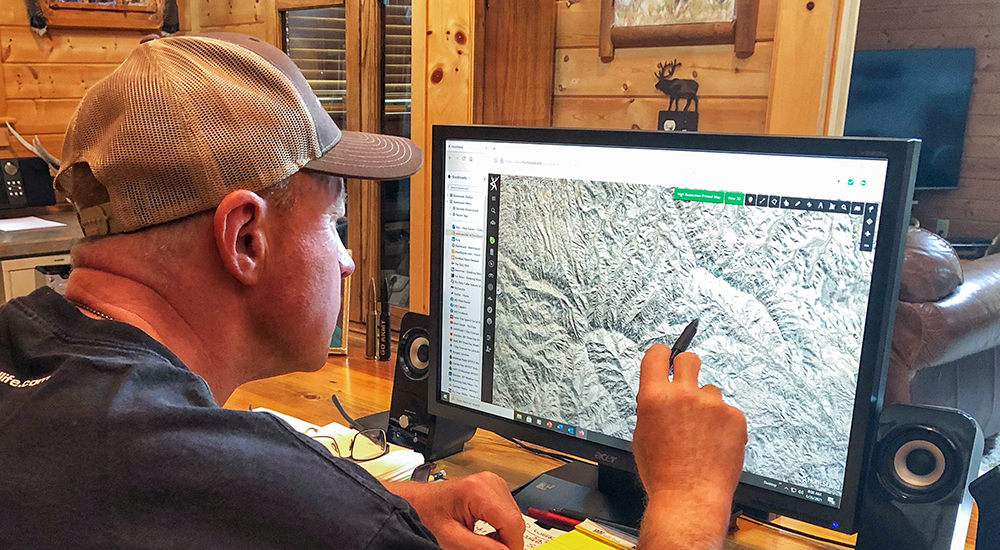 Man evaluating land terrain on computer.